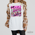 Model wearing a White No Dusty Bibles tee with pink and black script, a cross, stars, and colorful patterns.