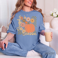 Blue Jean Pumpkin Season tee modeled with an orange pumpkin, retro flowers, checks, and cream script.
